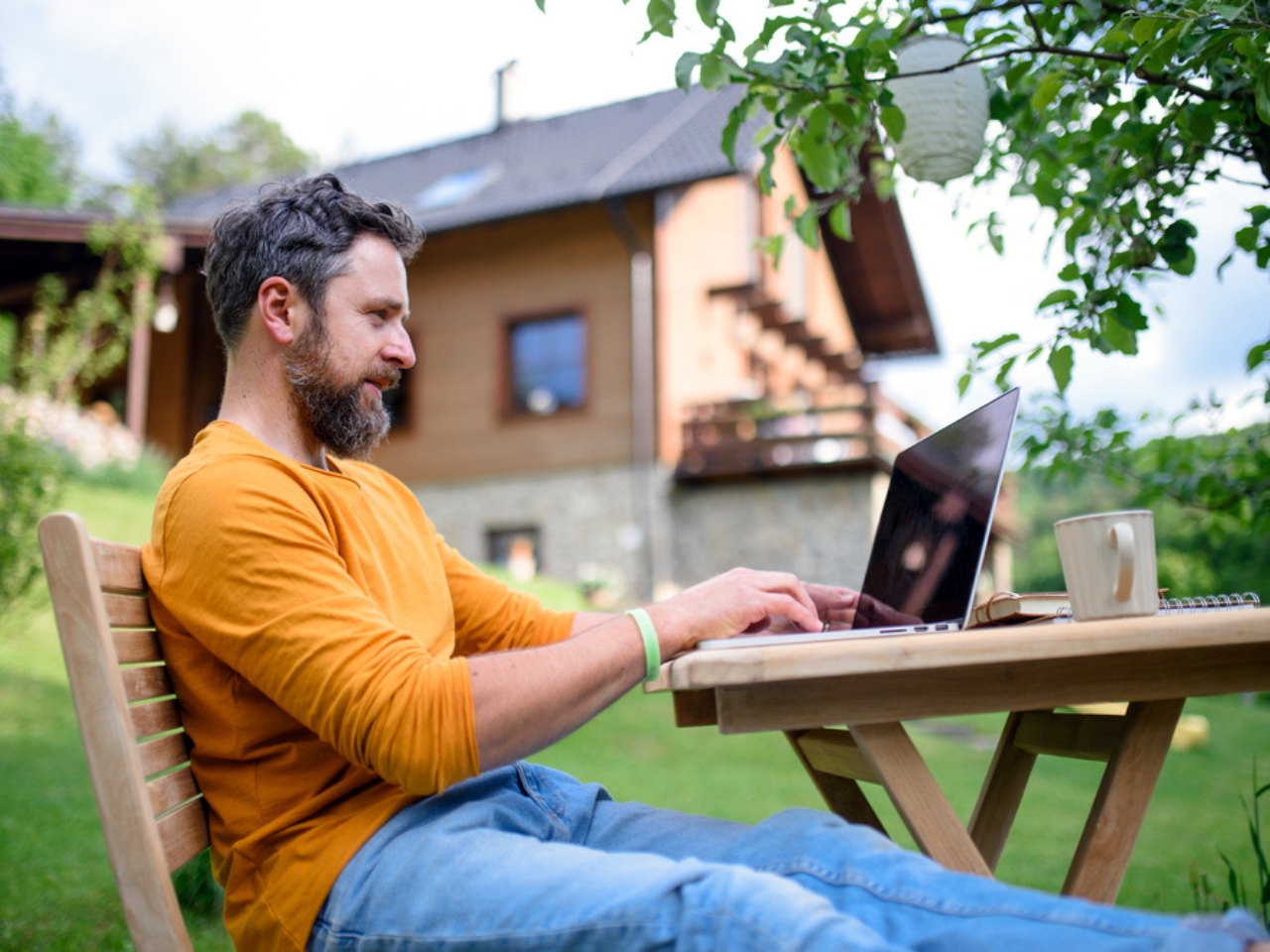 A man using 5G telecoms to remote work from his garden