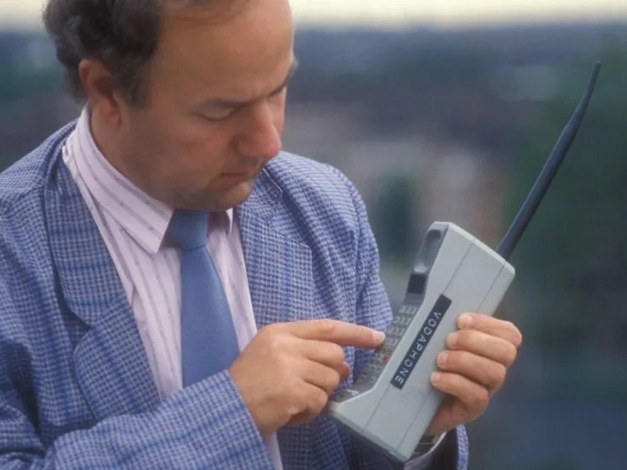 A BBC image of a man using an old mobile phone from the 1980s