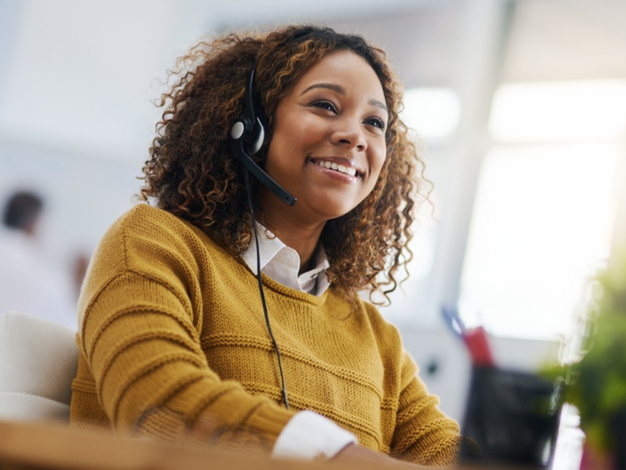 A customer service operator happily using her headset